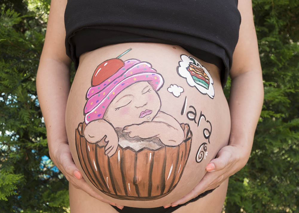 Pintura corporal para embarazada de bebe con dulce para