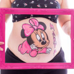 foto barriguita pintada con un dibujo de Minnie en tonos rosas