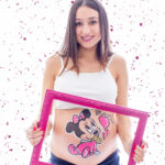 Sesión de Belly painting,con una embarazada posando,con la tripita pintada, con un diseño de Minnie Mouse.