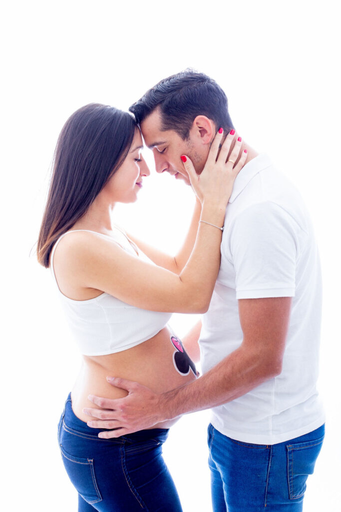 Foto de pareja en una sesion de belly paintig en estudio