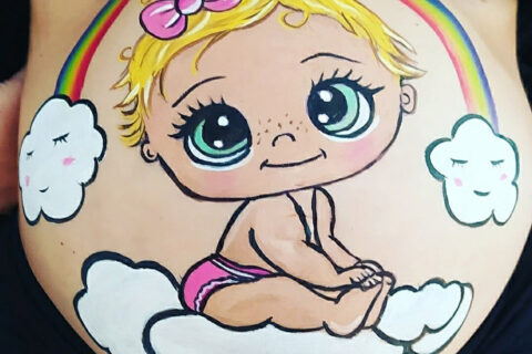 Foto de barriguita pintada en una sesión de baby shower con un diseño de un bebe arcoiris