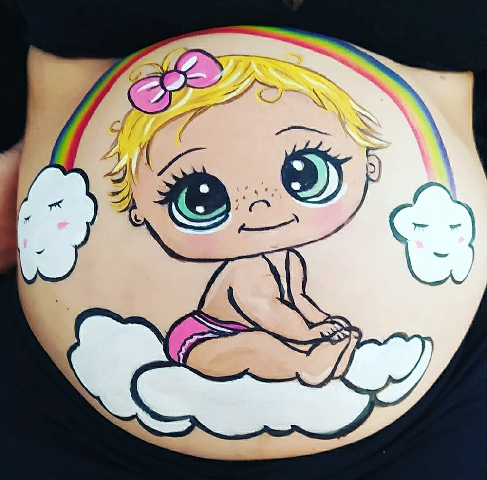 Foto de barriguita pintada en una sesión de baby shower con un diseño de un bebe arcoiris