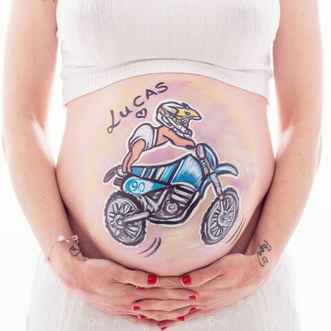 foto de tripita pintada de una mujer embarazada con un dibujo de un bebe motero