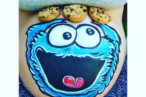 foto de tripita de embarazada pintada con un dibujo del moustro de las galletas en una fiesta baby shower en madrid