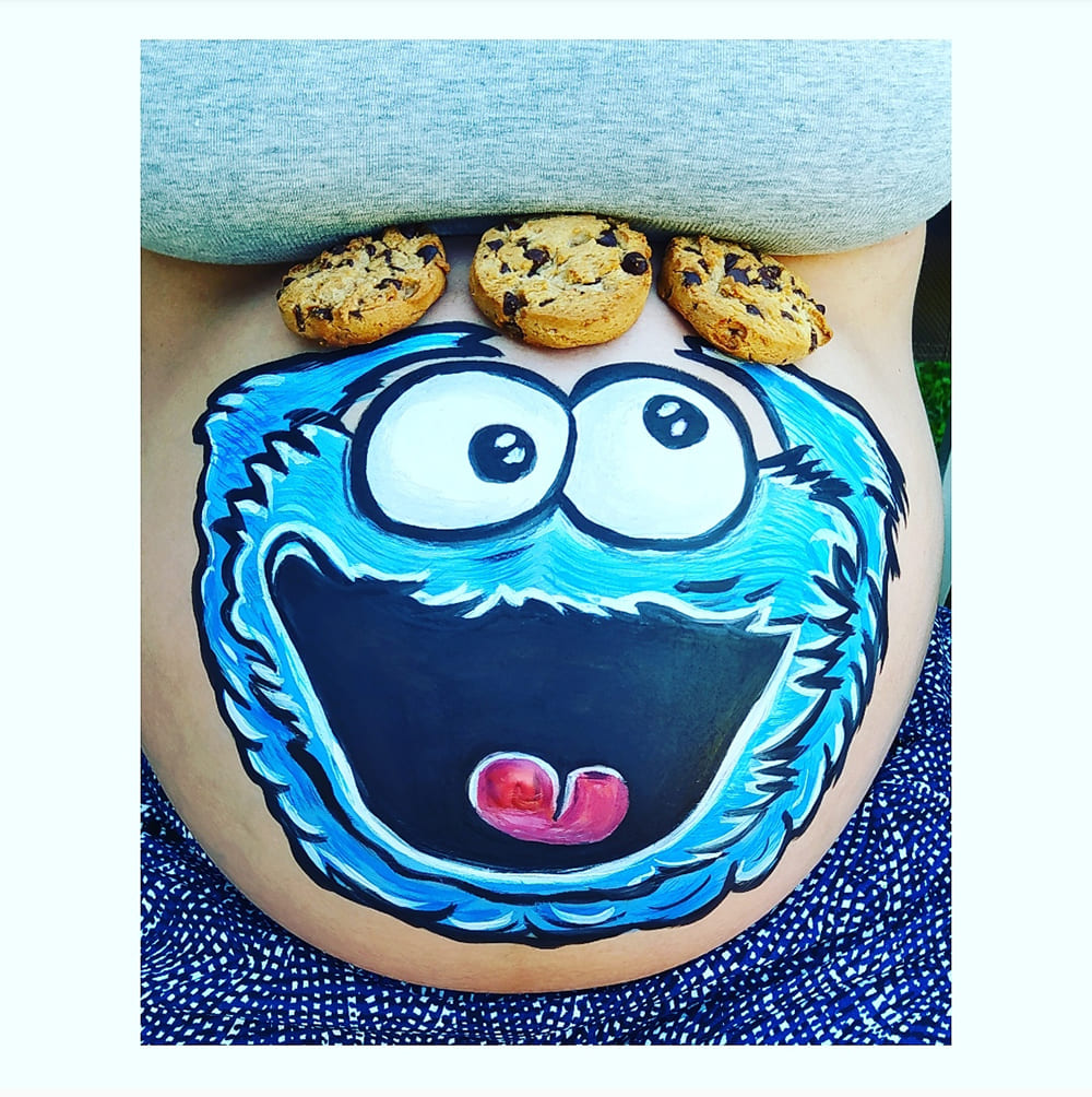 foto de tripita de embarazada pintada con un dibujo del moustro de las galletas en una fiesta baby shower en madrid