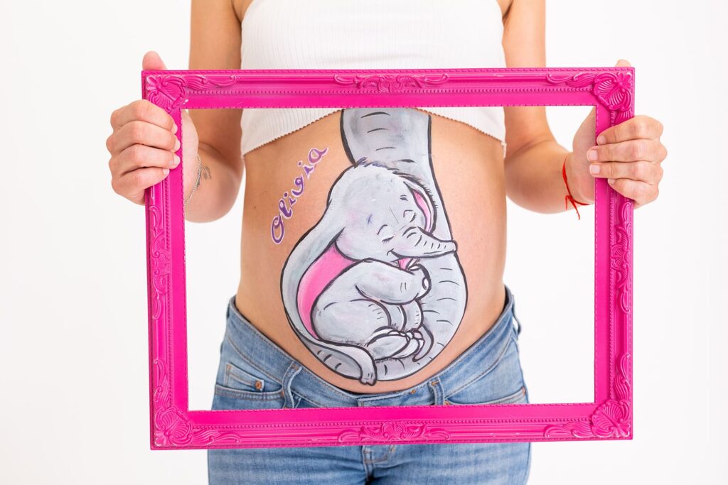 foto de barriguita pintada con un dibujo de un elefante con tonos grises en una sesion de belly painting en estudio