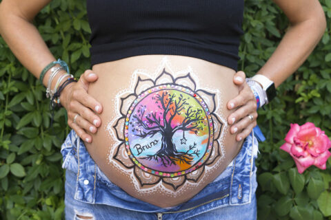 foto de tripita pintada de una mujer embarazada en su baby shower en leganes con un dibujo del arbol de la vida con muchos colores