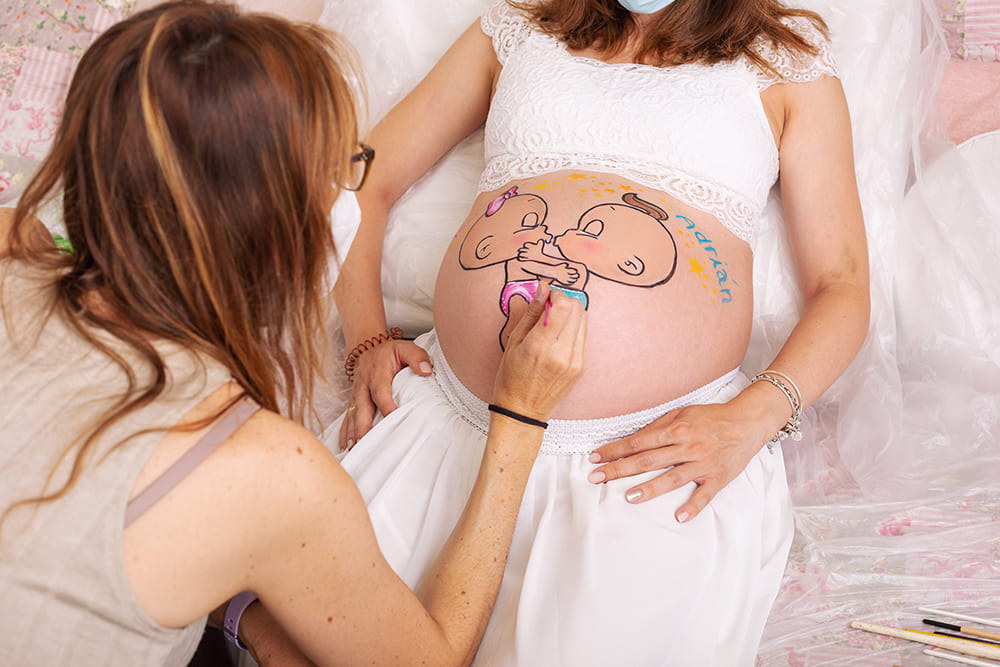 yo pintando a una embarazada en una sesion de belly painting en estudio