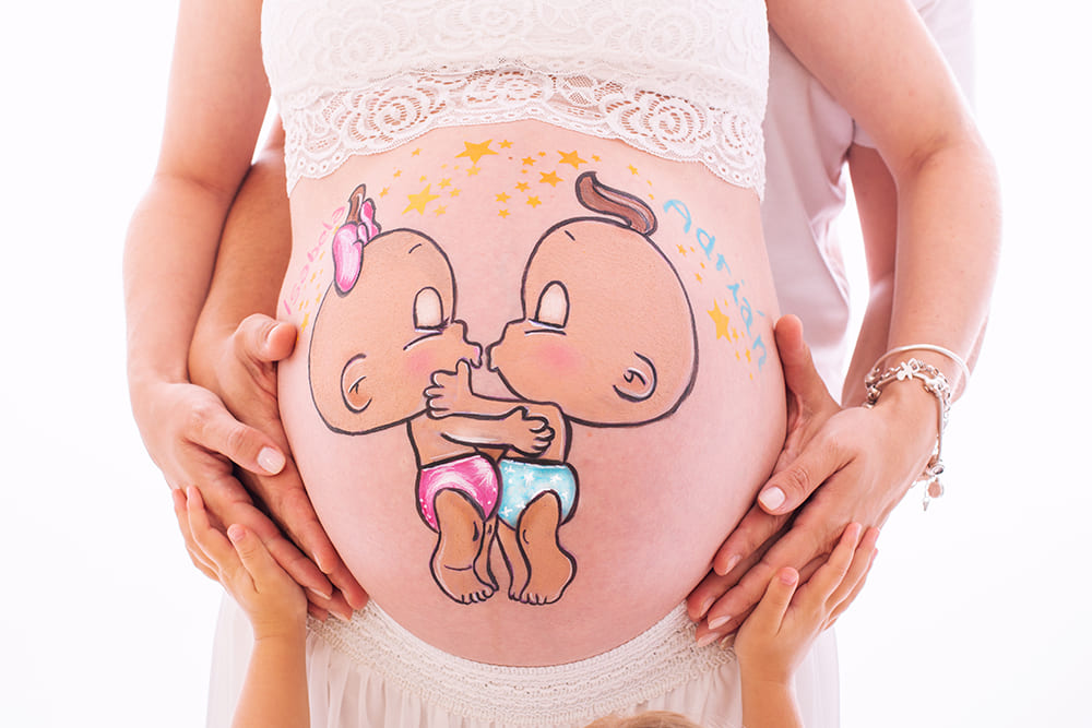 foto de barriguita pintada de gemelos en una sesion de belly painting en estudio